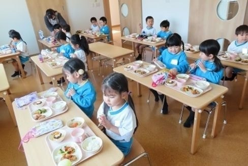 給食を食べる幼稚園児