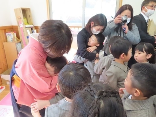 あざみ野こども園の卒園式で先生と抱き合う園児