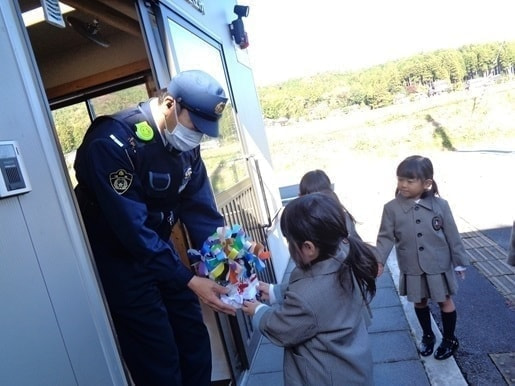 あざみ野こども園の園児が警察官に花を渡す