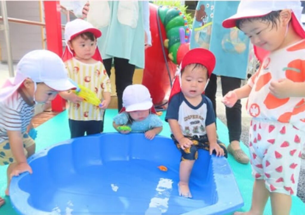 プールで水の冷たさや感触を楽しむめばえ組の子どもたち